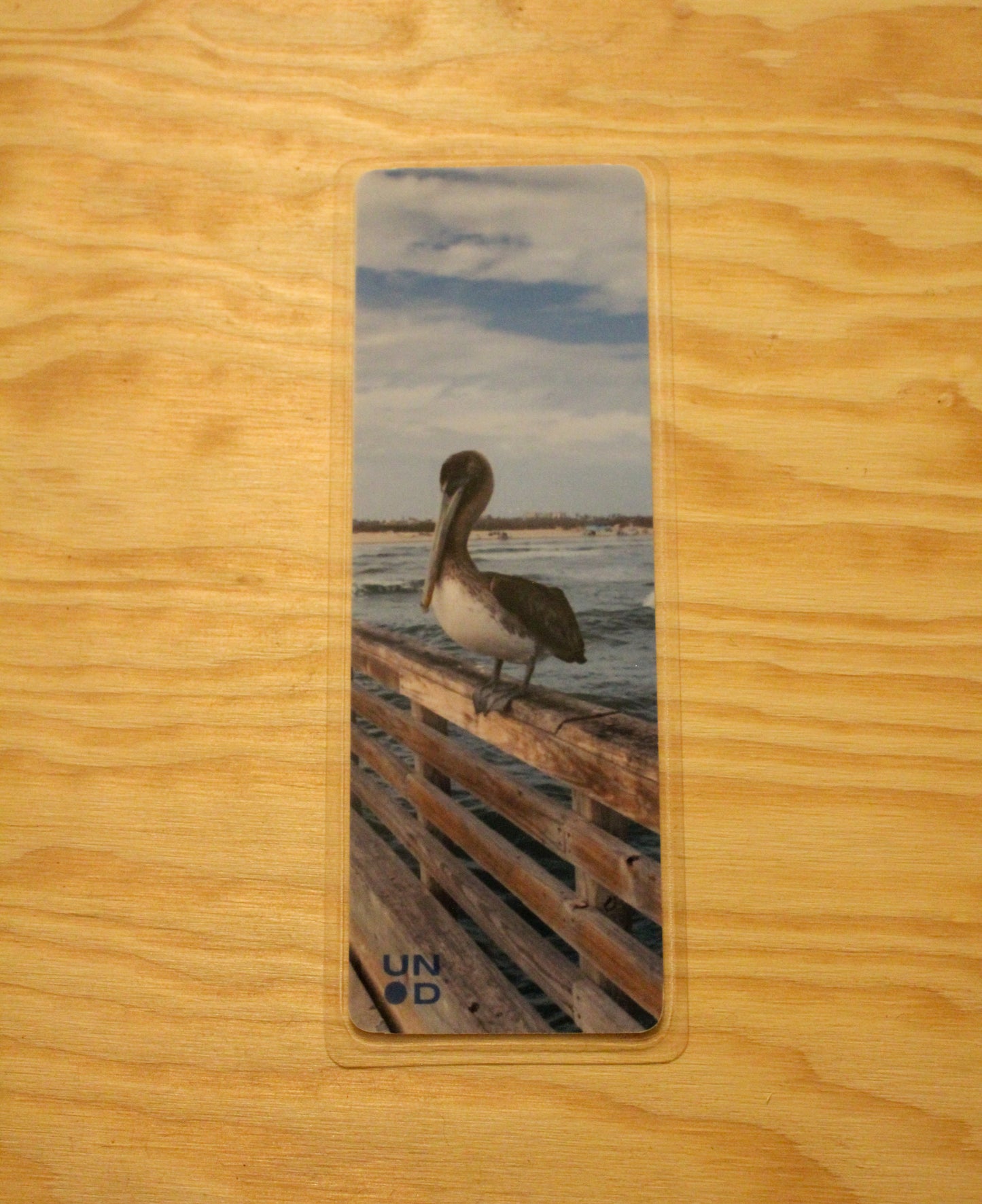 bookmark with a pelican on a wooden surface