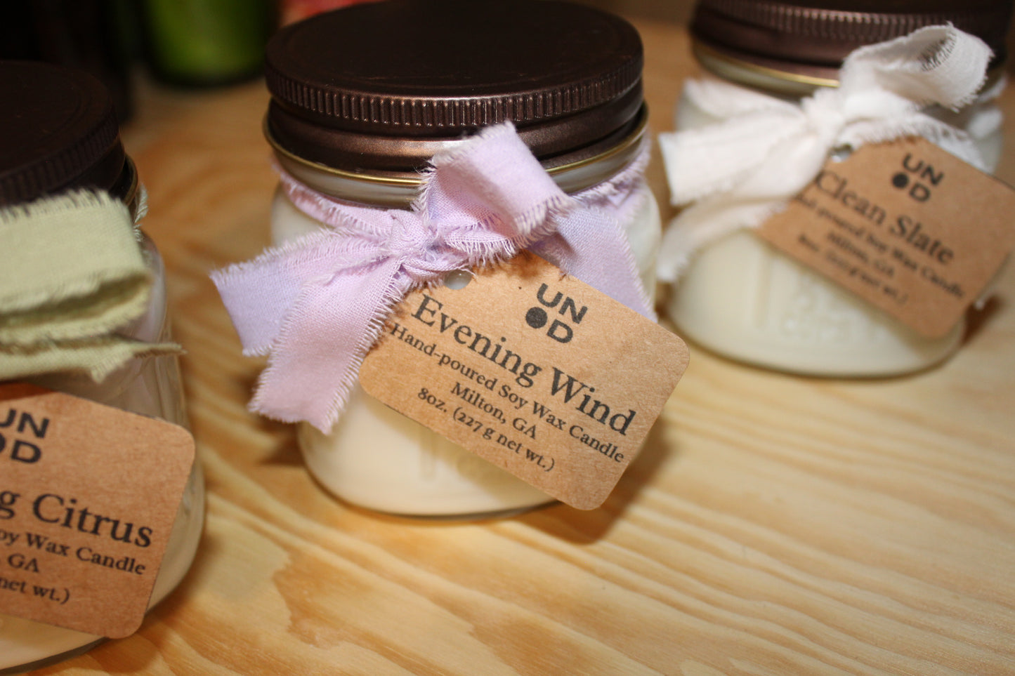 Jar of candle with a label on a wooden surface