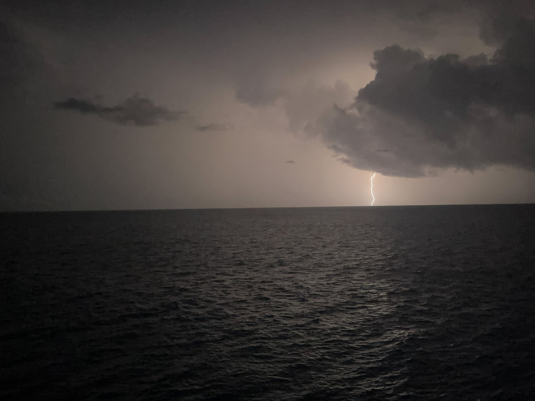 lightning strike against the ocean with clouds