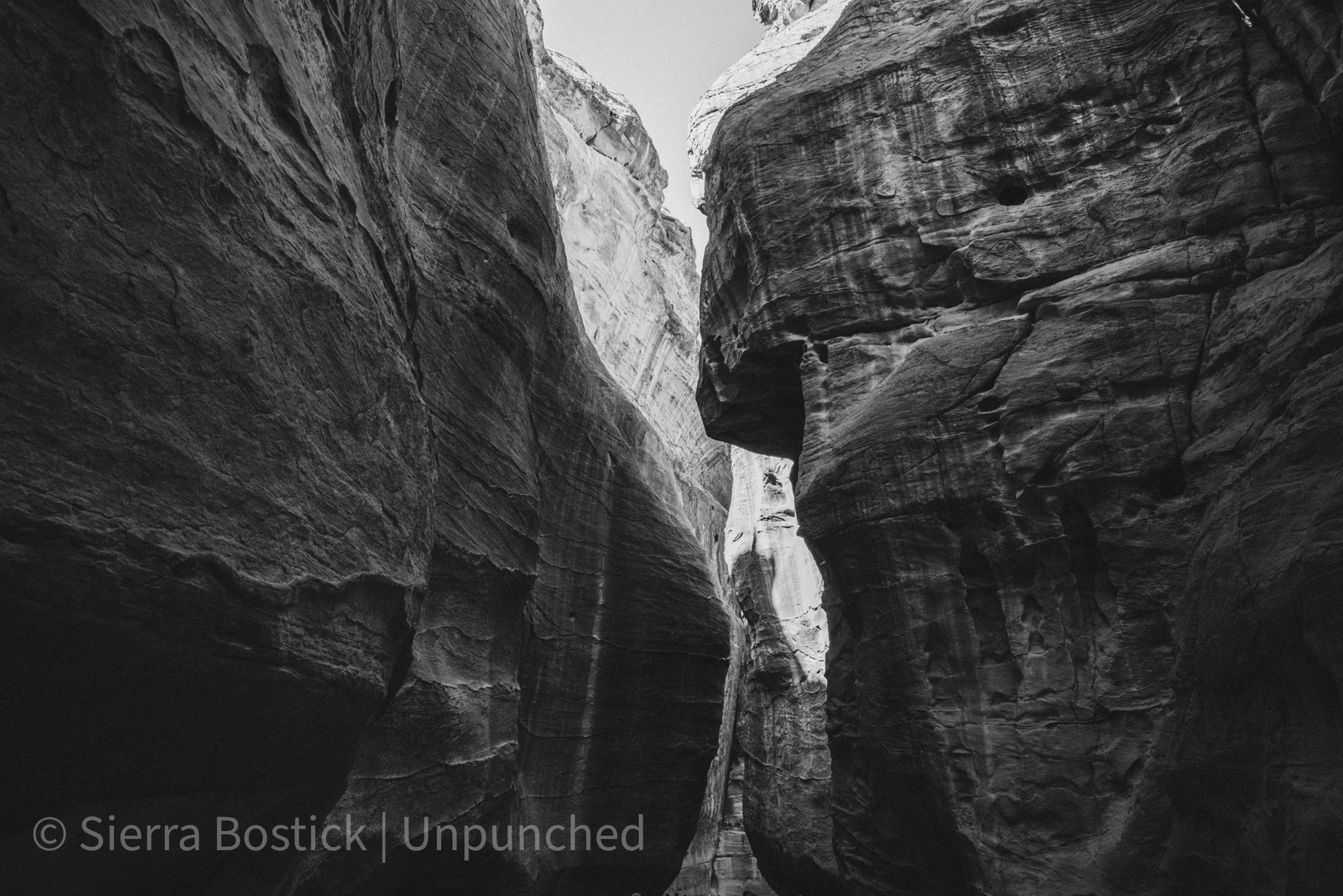 Upward view of the Al Siq Canyon in Jordan. A black and white version of the color photo in greyscale.