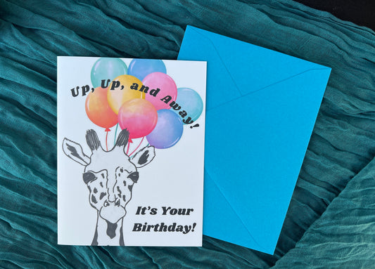 Greeting card with balloons and giraffe illustration on a teal fabric background