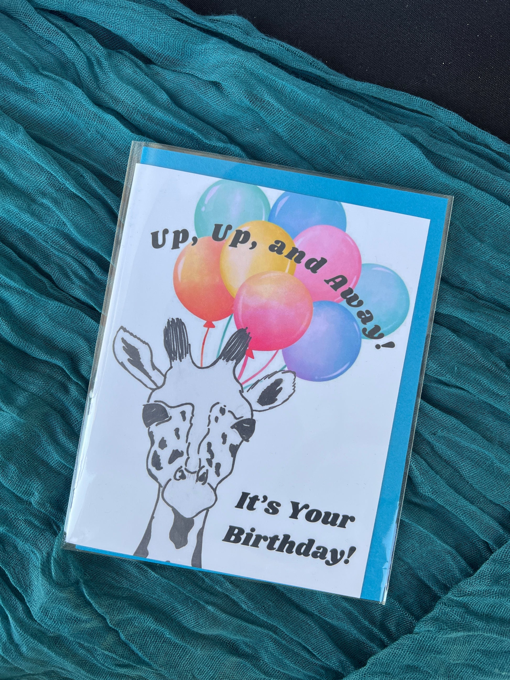 Birthday card with colorful balloons and text on a teal fabric background