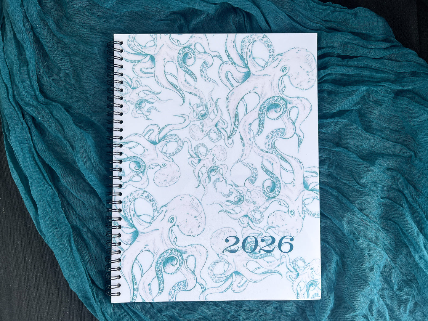 Spiral-bound notebook with 2026 octopus design on a textured teal fabric background