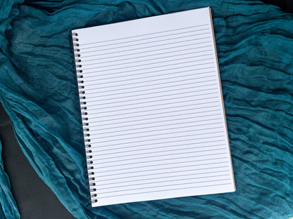 Blank notebook on a textured teal fabric background