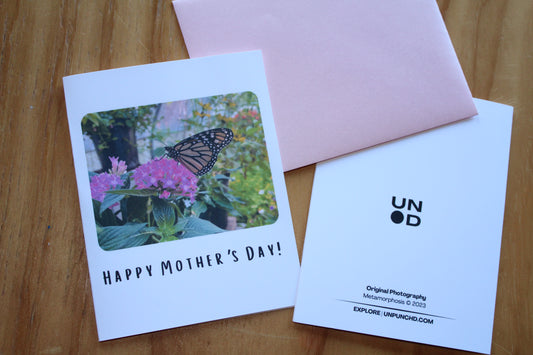 "Happy Mother's Day" with an image of a monarch butterfly landing on a pink flower. Pink Envelope and back of the card with Unpunchd logo and image information. 