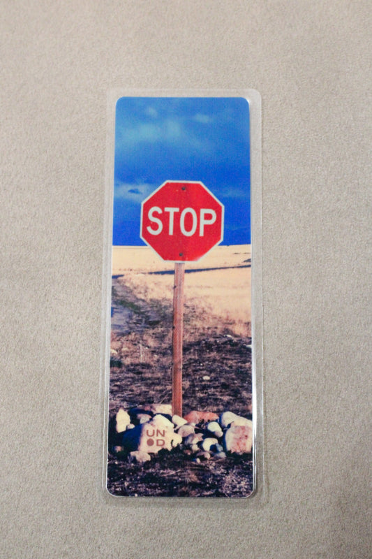 Stop sign with pebbles on a road in a scenic background