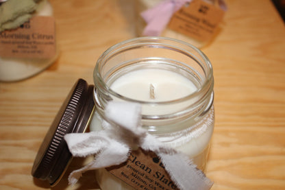 Candle in a glass jar with a label on a wooden surface