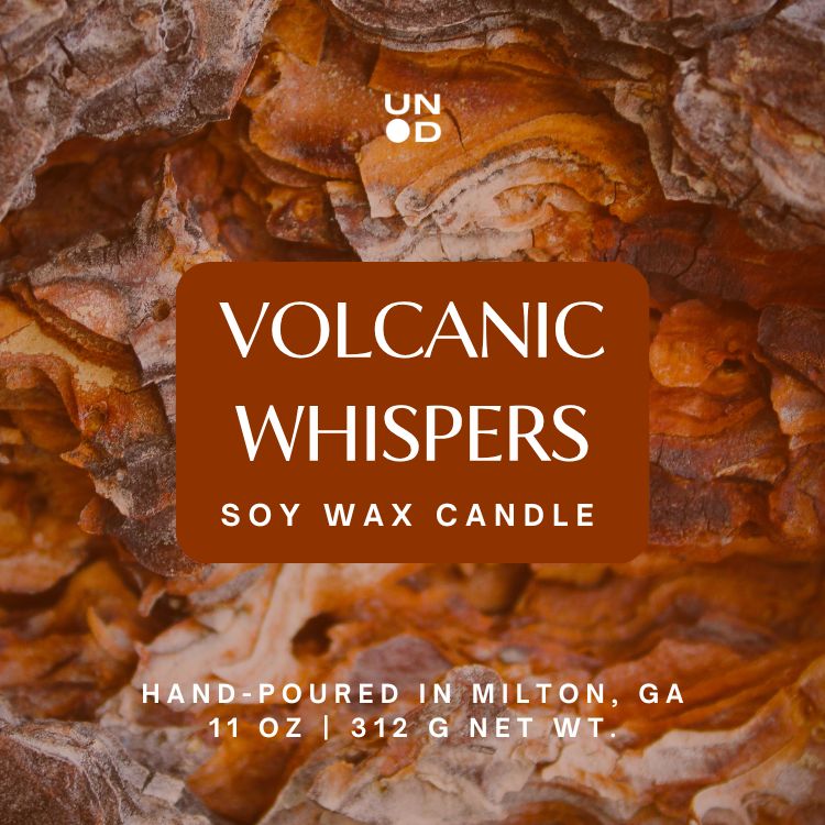 Soy wax candle labeled 'Volcanic Whispers' with volcanic rock texture in the background
