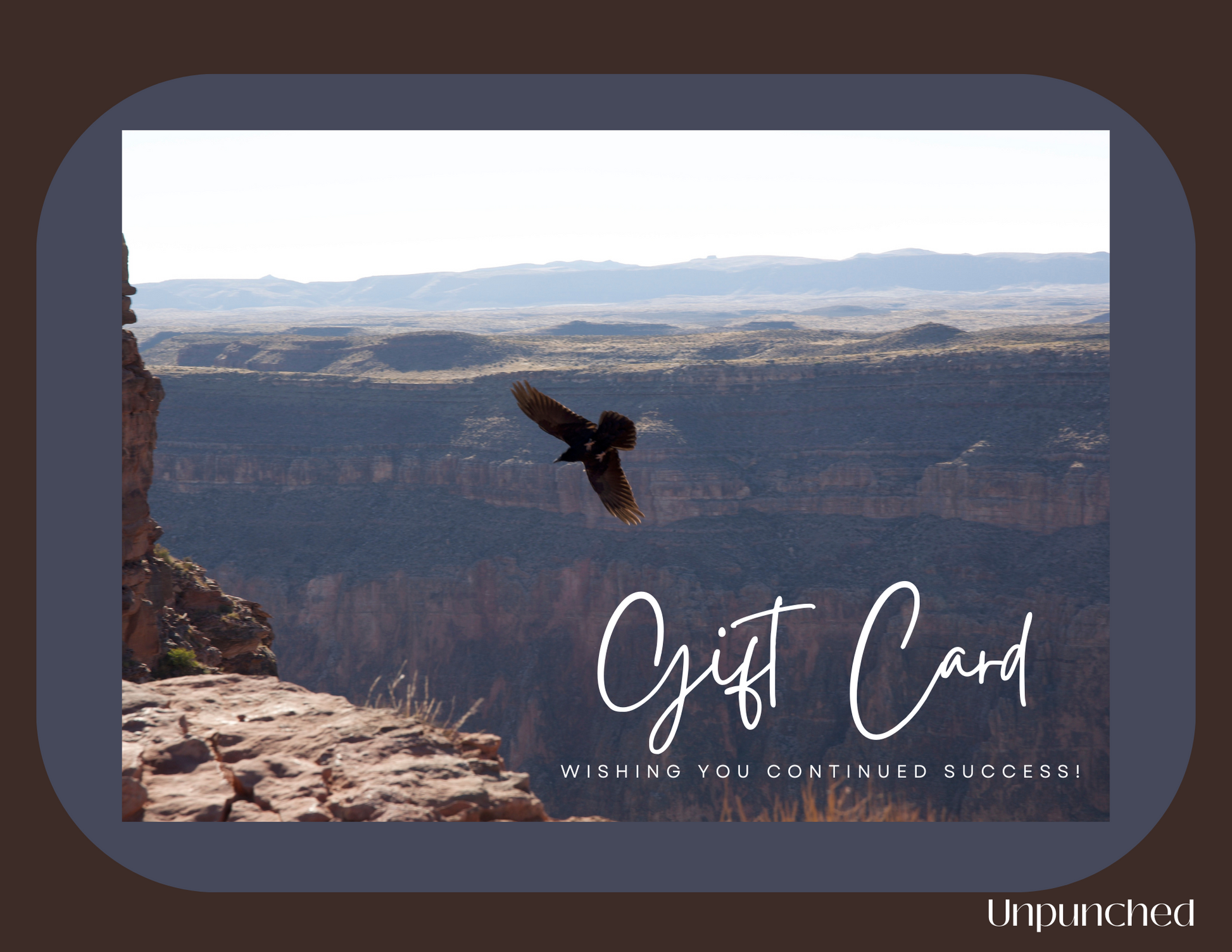 Brown rectangle with a taupe blue card overlay with a picture of a raven soaring into a canyon. In the bottom right corner, the picture reads "Gift Card Wishing You Continued Success!" In the bottom right corner of the rectangle it reads the Unpunched logo. Hues of browns and blues with white writing.